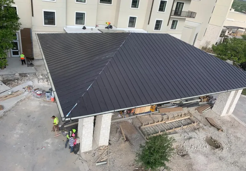 Metal roofing installation team working on a commercial building in College